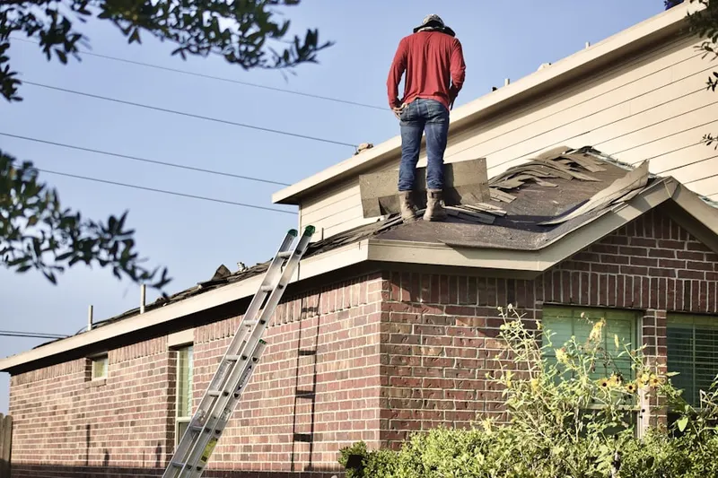 Professional roofer working on a residential roof in Roads